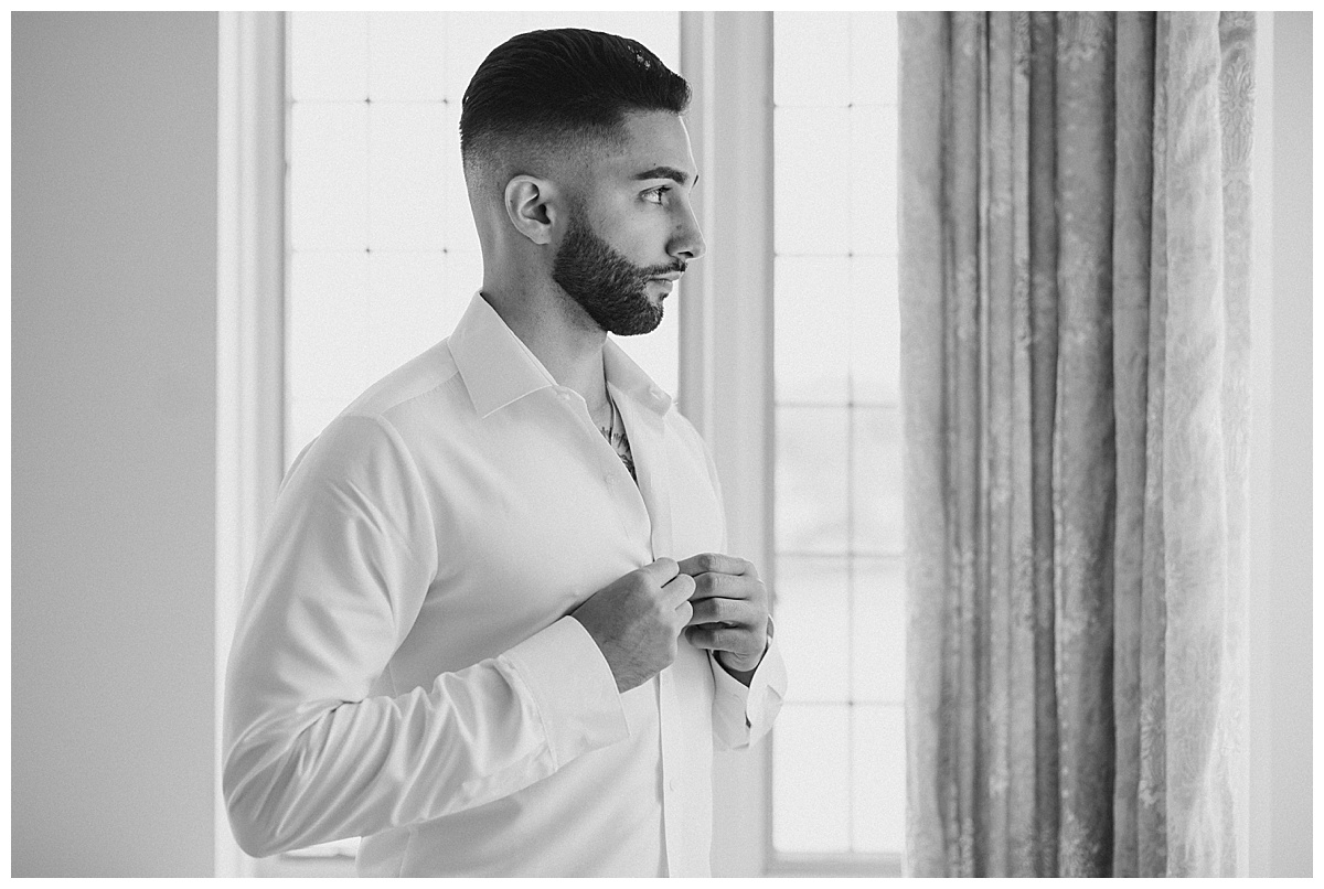groom getting ready in black and white on wedding day 