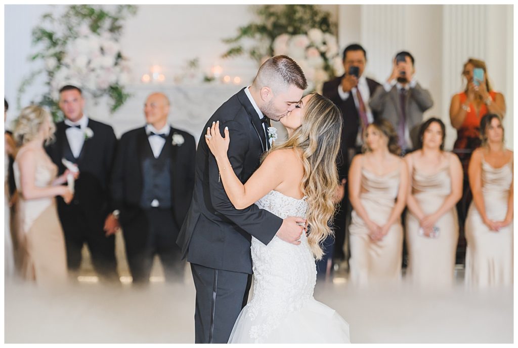 bride and groom kissing on dance floor 