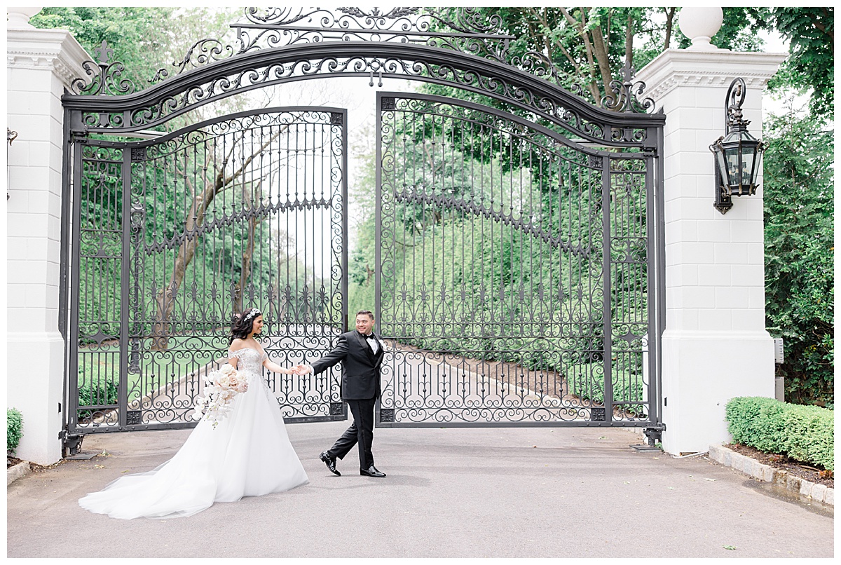bride and groom in front of gates at shadowbrook at Shrewsbury