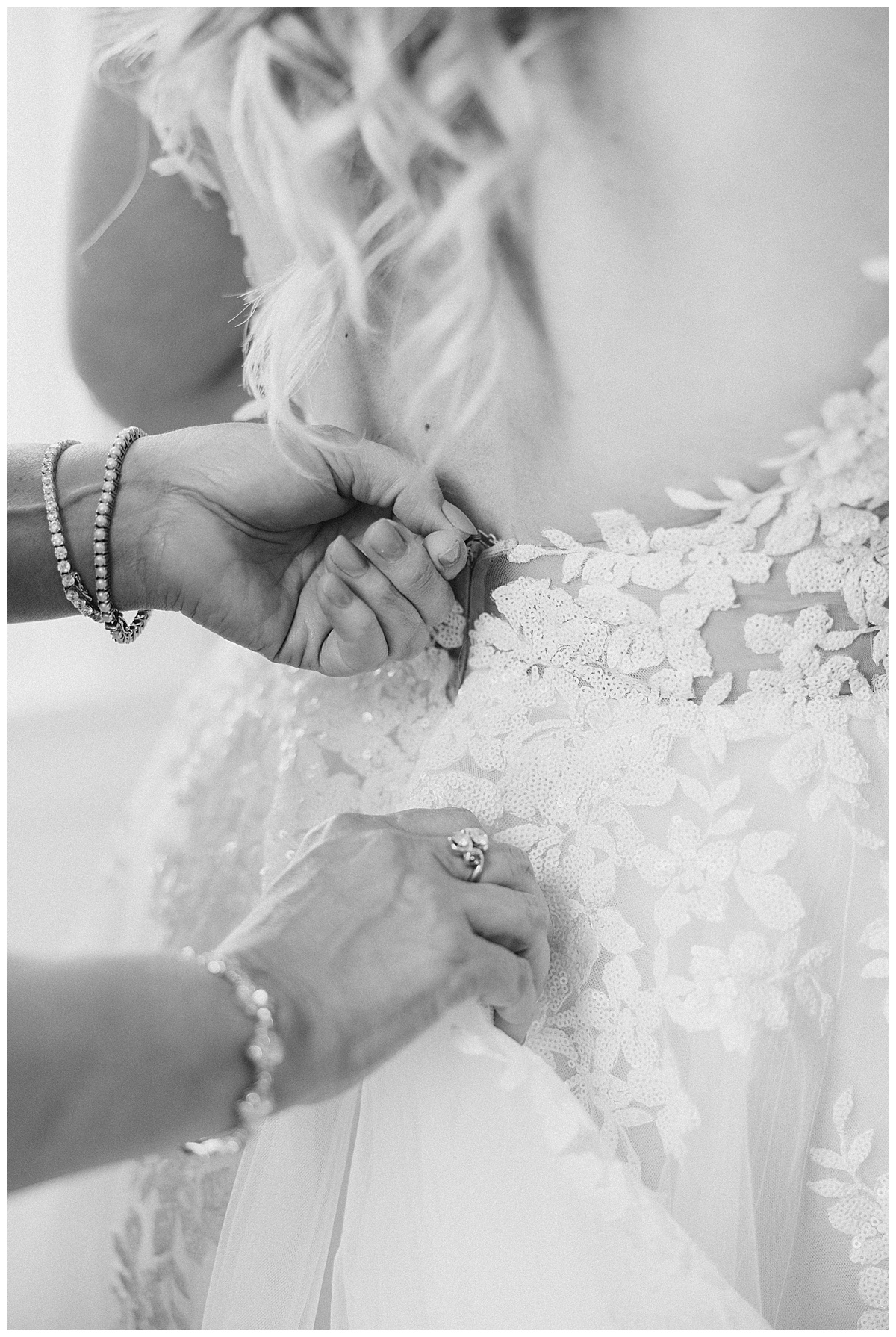mom zipping daughter in wedding dress