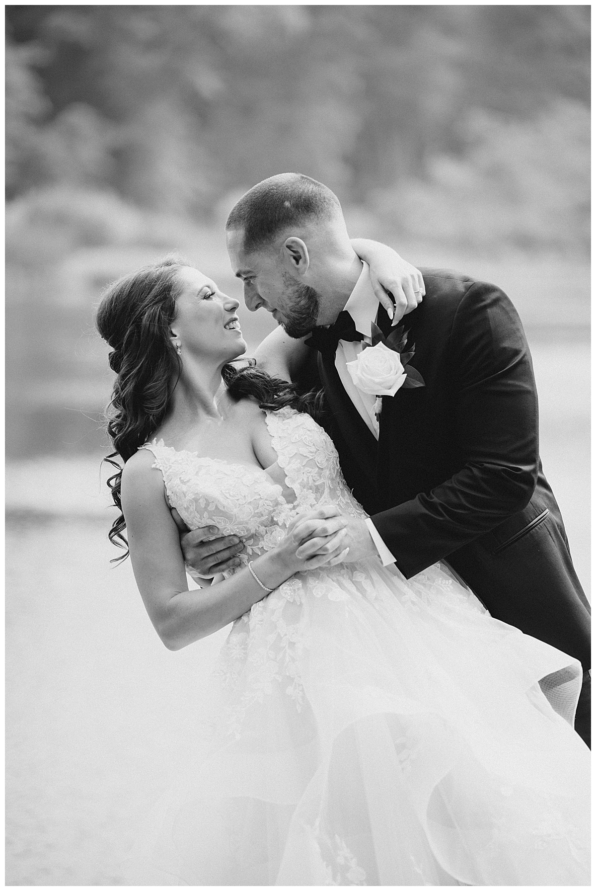 black and white image of bride and groom on lake