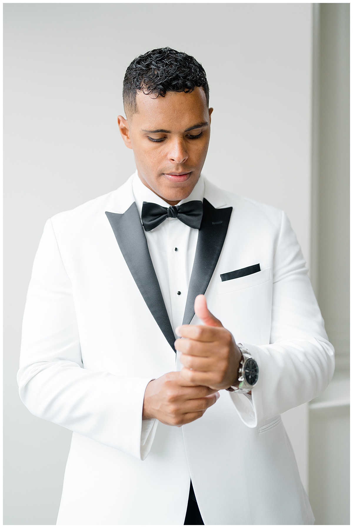 groom with watch in white tux at park chateau 