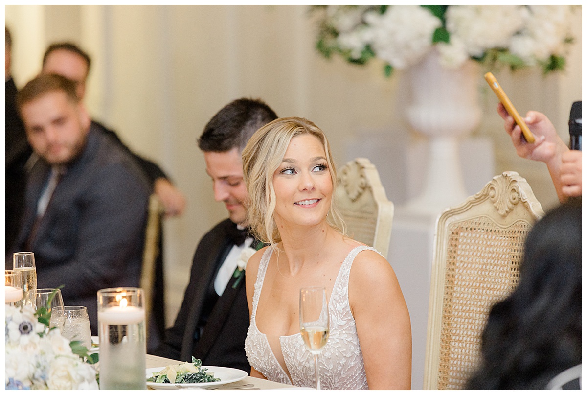 Bride smiling at wedding speech 