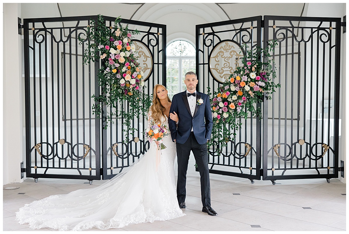 Bride and groom with soft smiles in front of ceremony gate at Shadowbrook at Shrewsbury. 