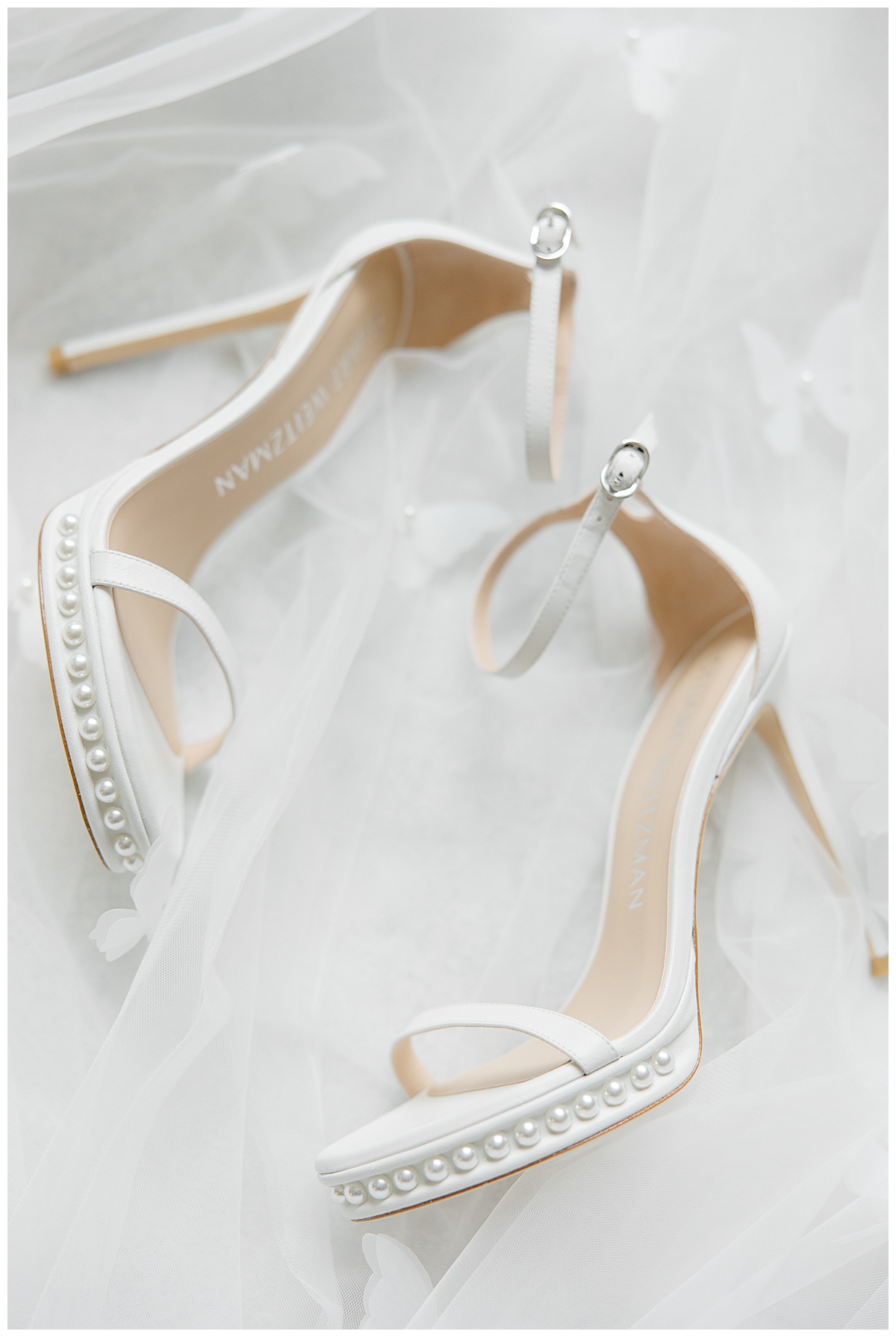 Stuart Weitzman wedding shoes laying on veil. 
