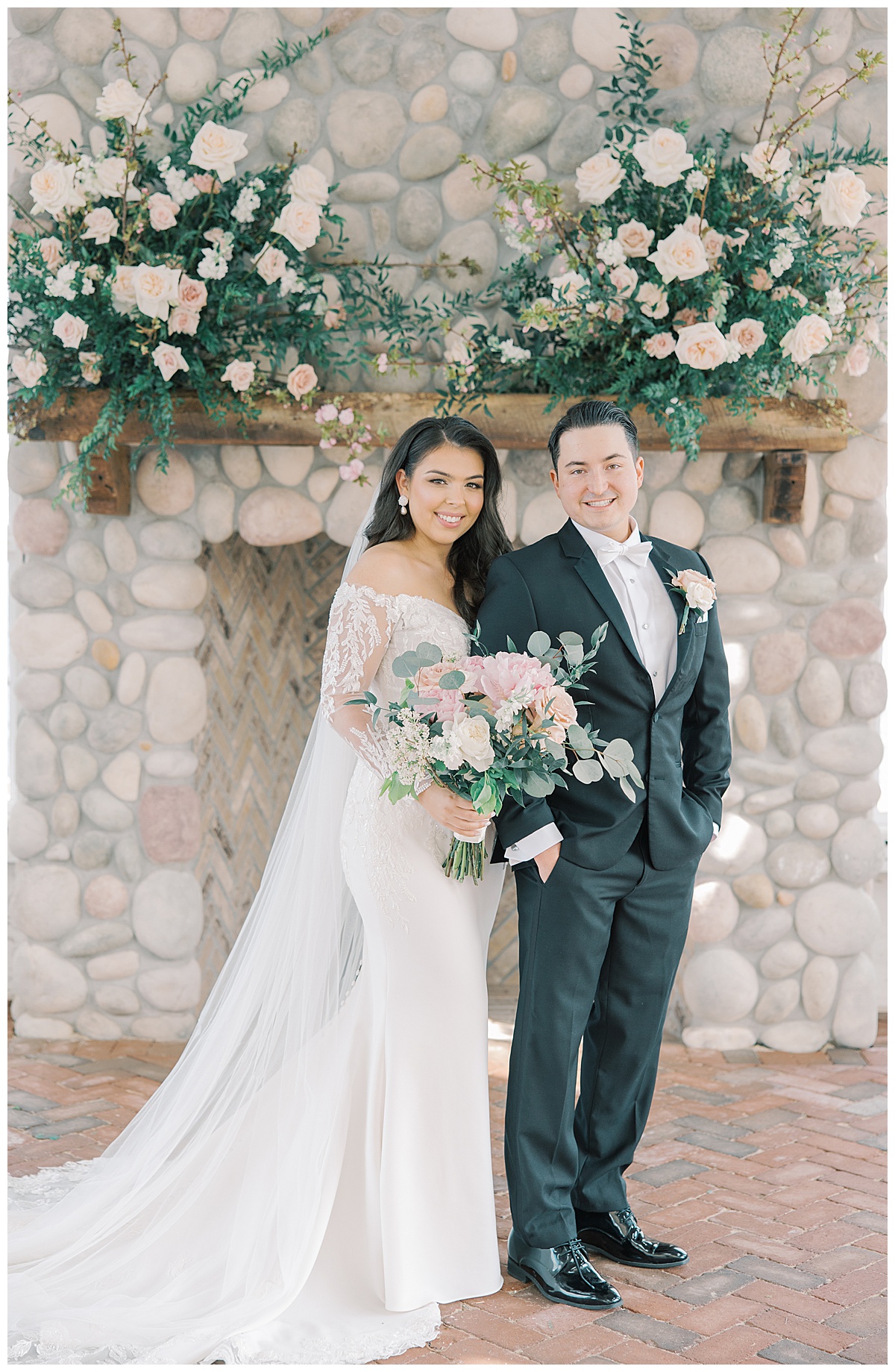 Bride and groom smile together on their wedding day with stone fireplace and mantel decor at Mallard Island Yacht Club. 