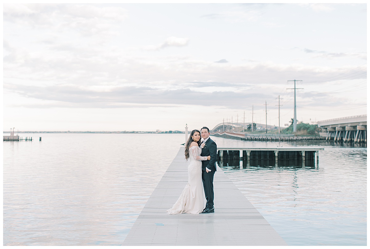 Bride and groom hugging on the bay at Mallard Island Yacht Club. 