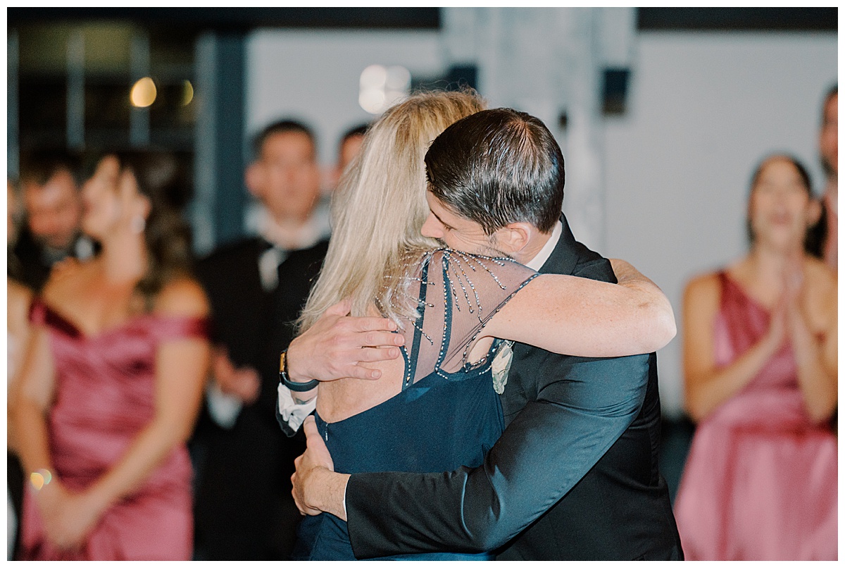 groom and mom hug each other after dancing on wedding day 