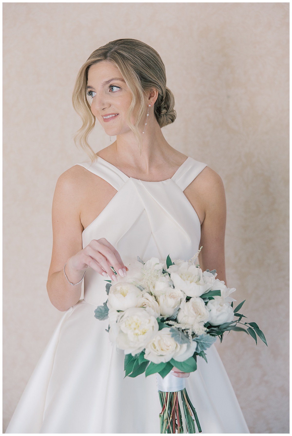 Bridal portraits with white and green bouquet and satin wedding gown. 
