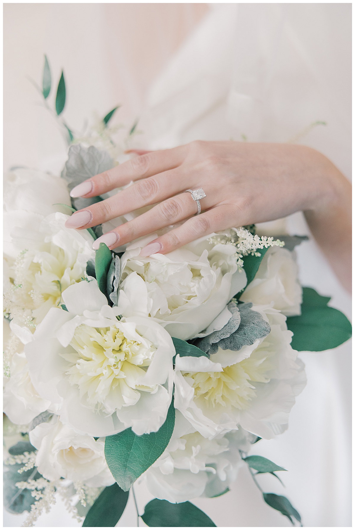 cushion cut engagment ring on bouquet on wedding day. 
