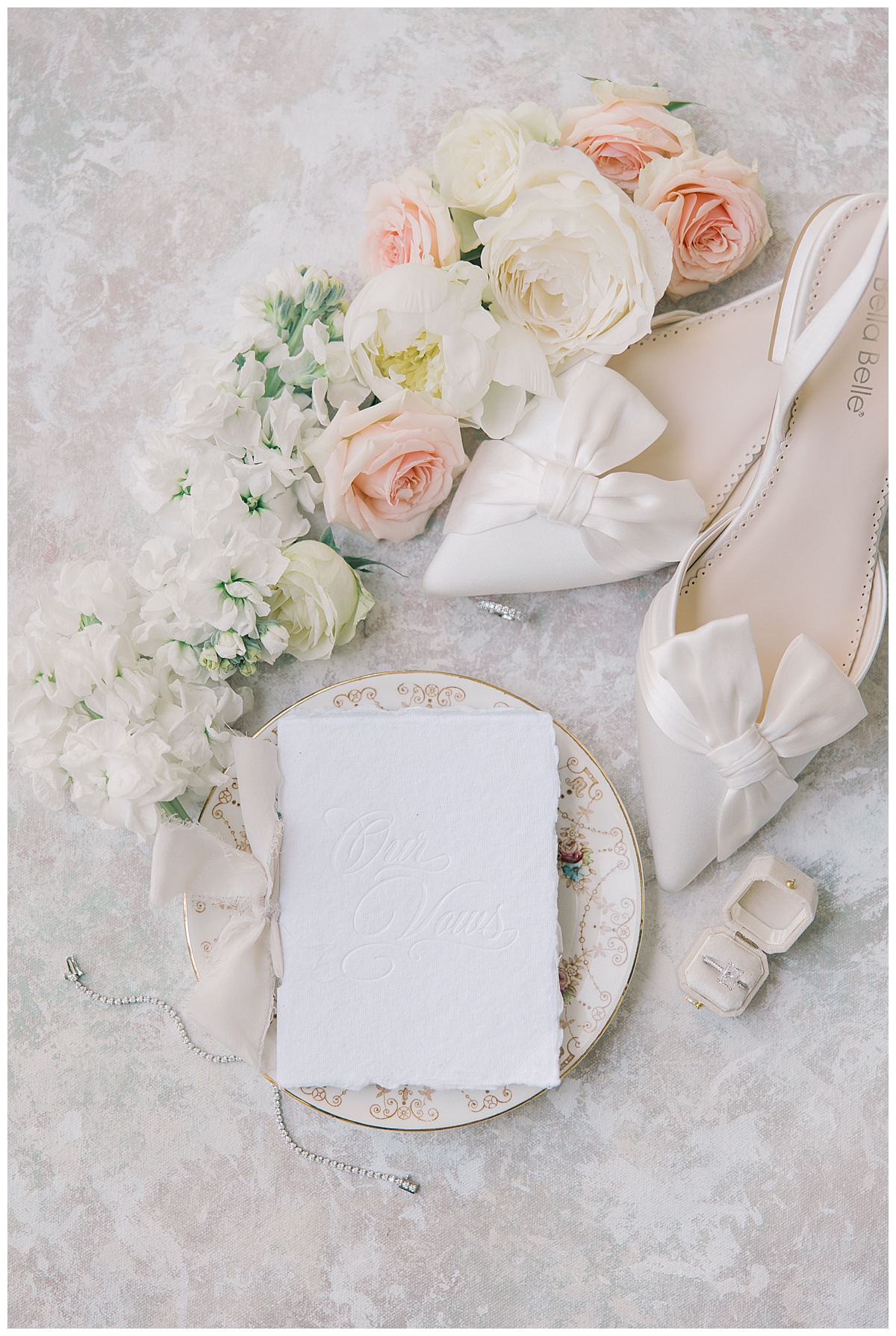 vow book on antique plate with white + pink roses. 