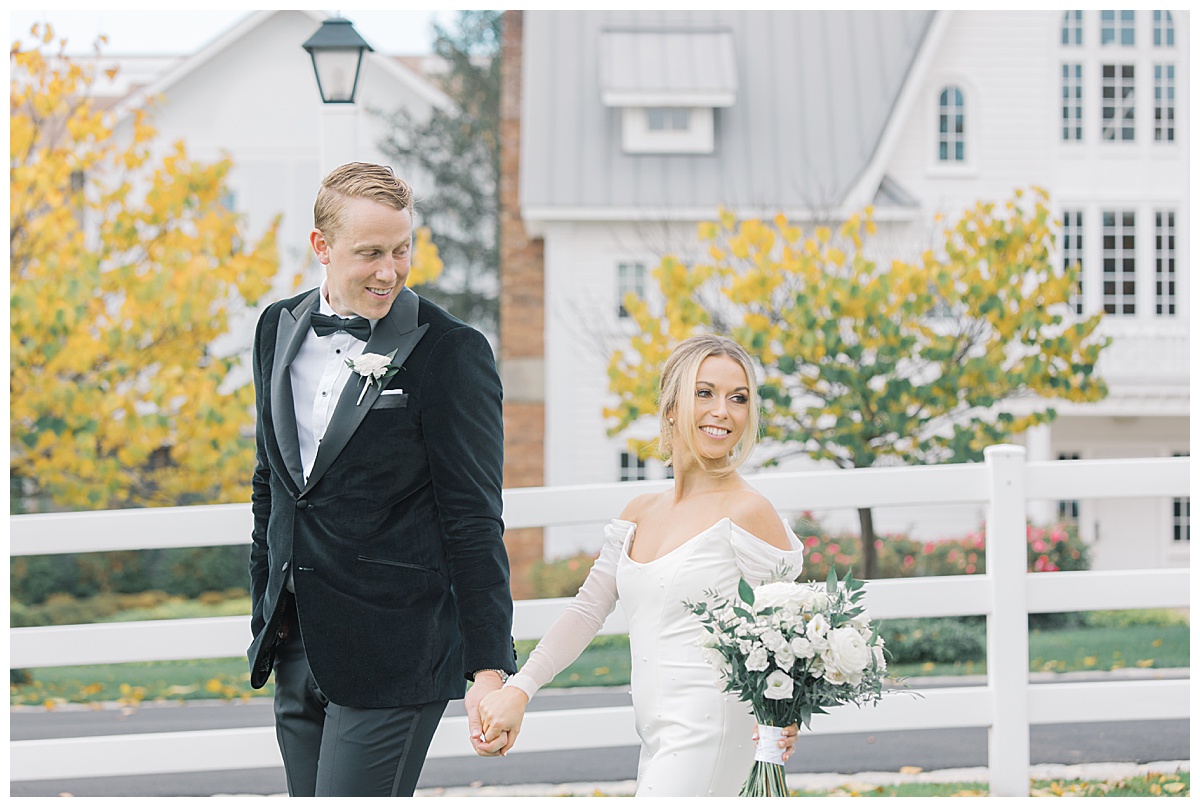 Groom walking with bride during fall wedding at The Ryland Inn. 