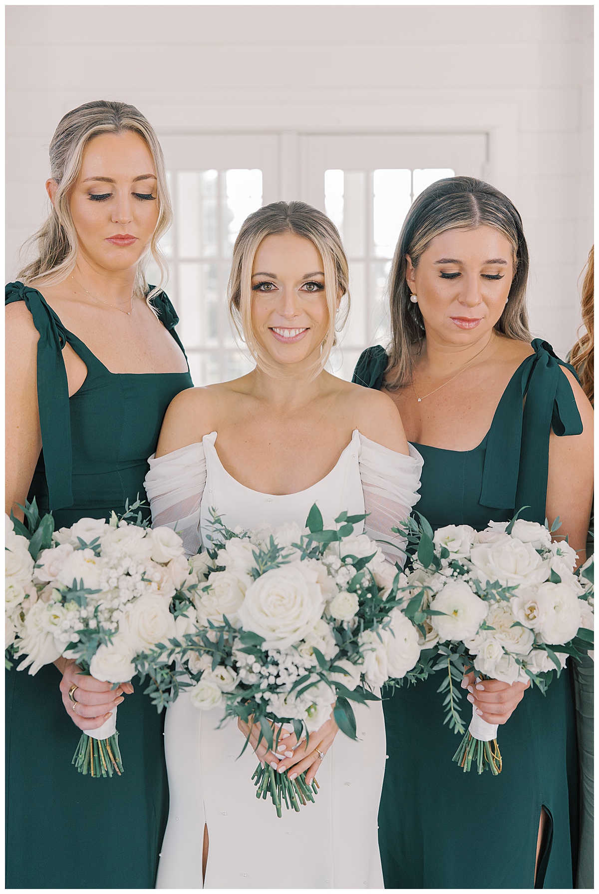 Bride with green bridesmaid dresses and white and green bouquets. 