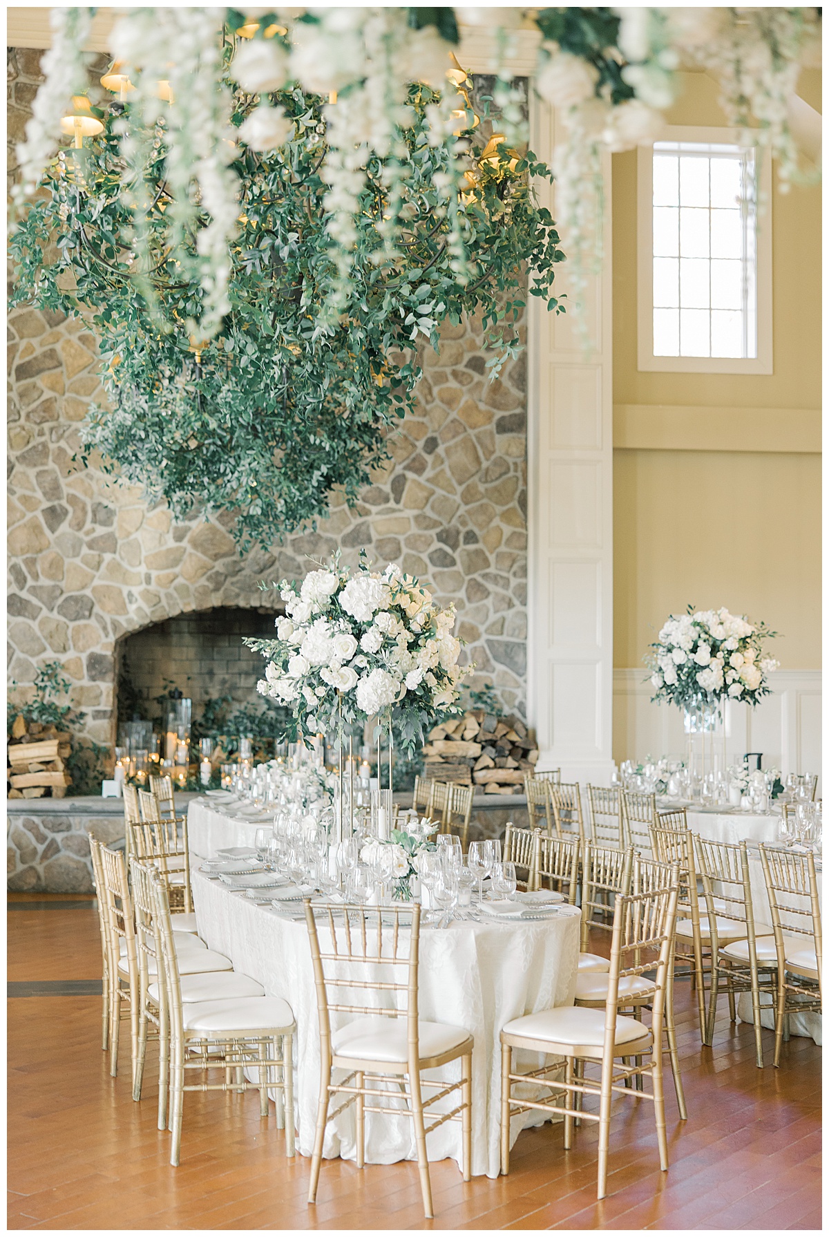 The Ryland Inn grand ballroom reception with white and green florals and greenery hanging from the chandeliers. 