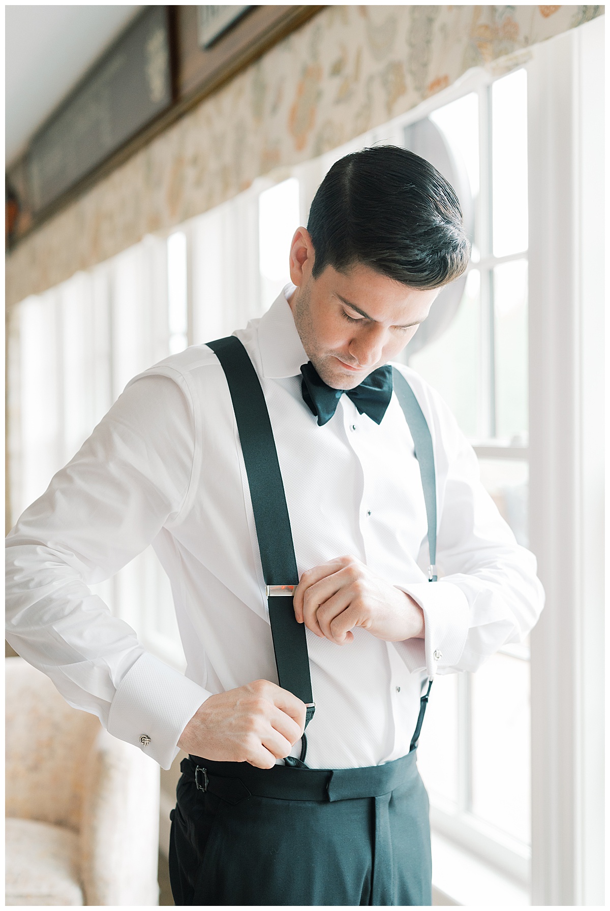 groom fixing his suspenders on wedding day 