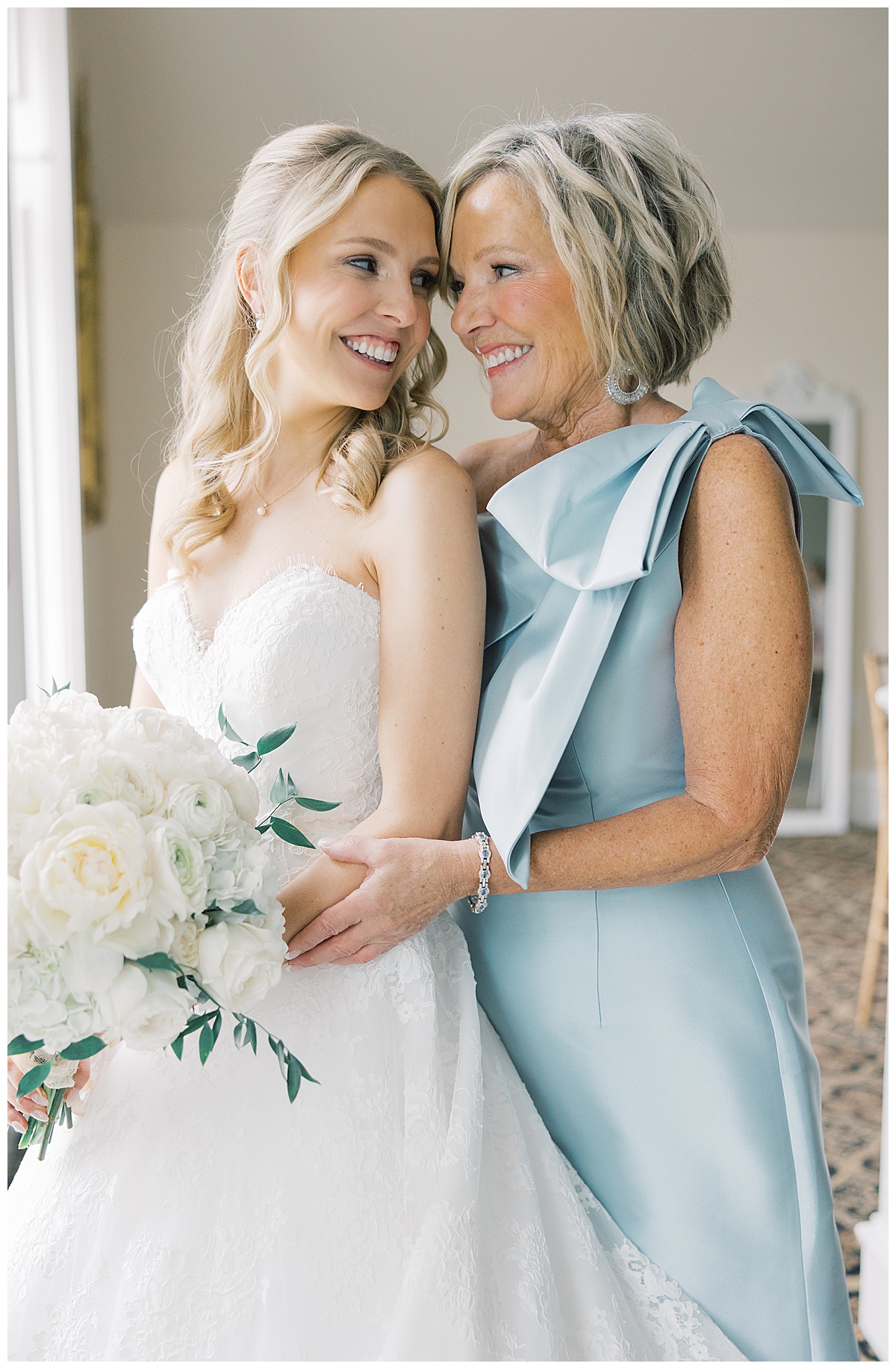 bride and mom sharing a hug on her wedding day while she gets ready 