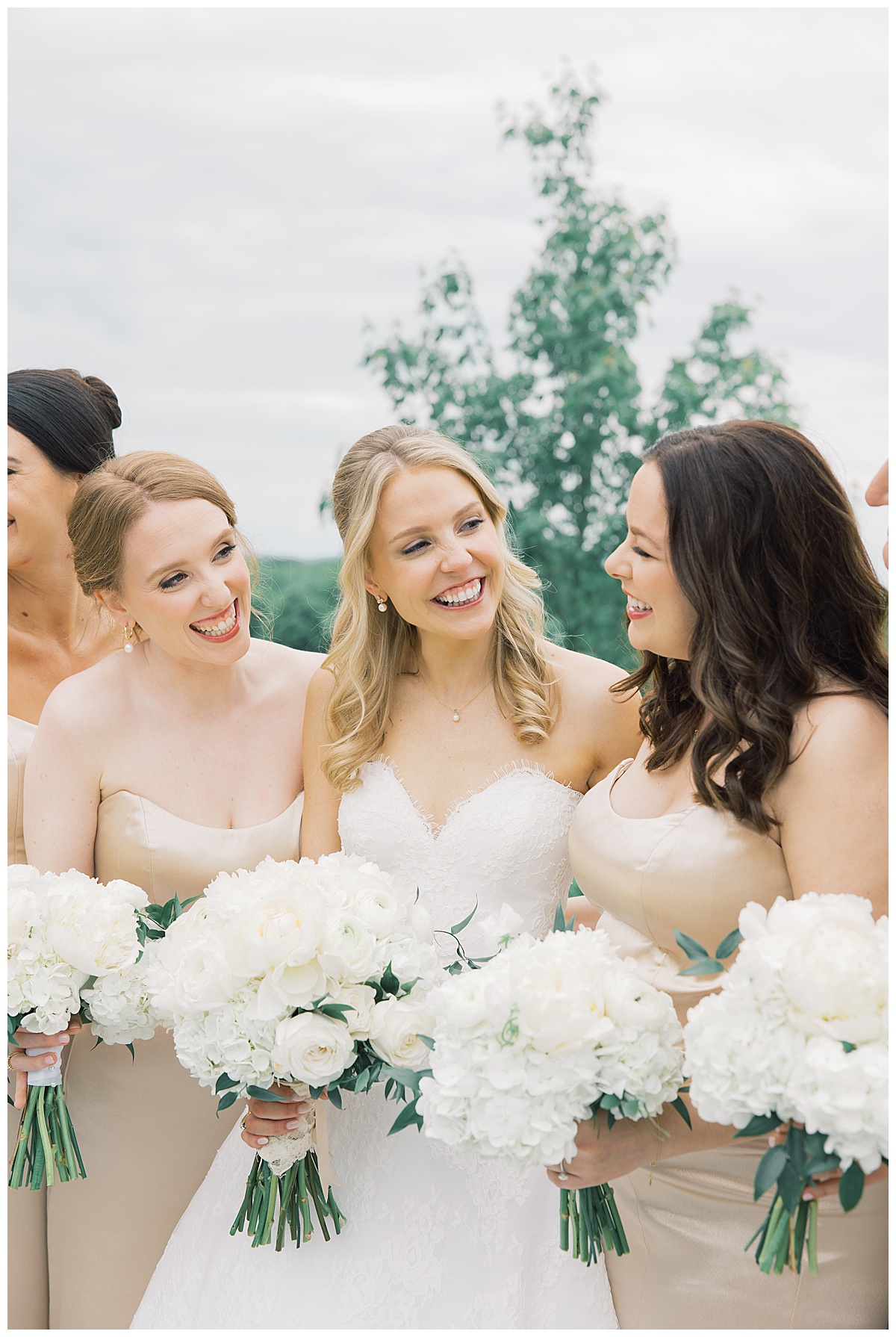 bride with her bridesmaids holding white bouquets 