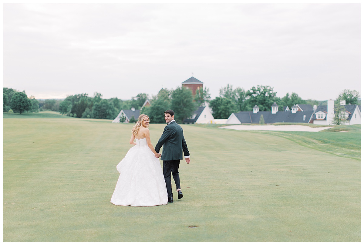 bride and groom running together on golf course 