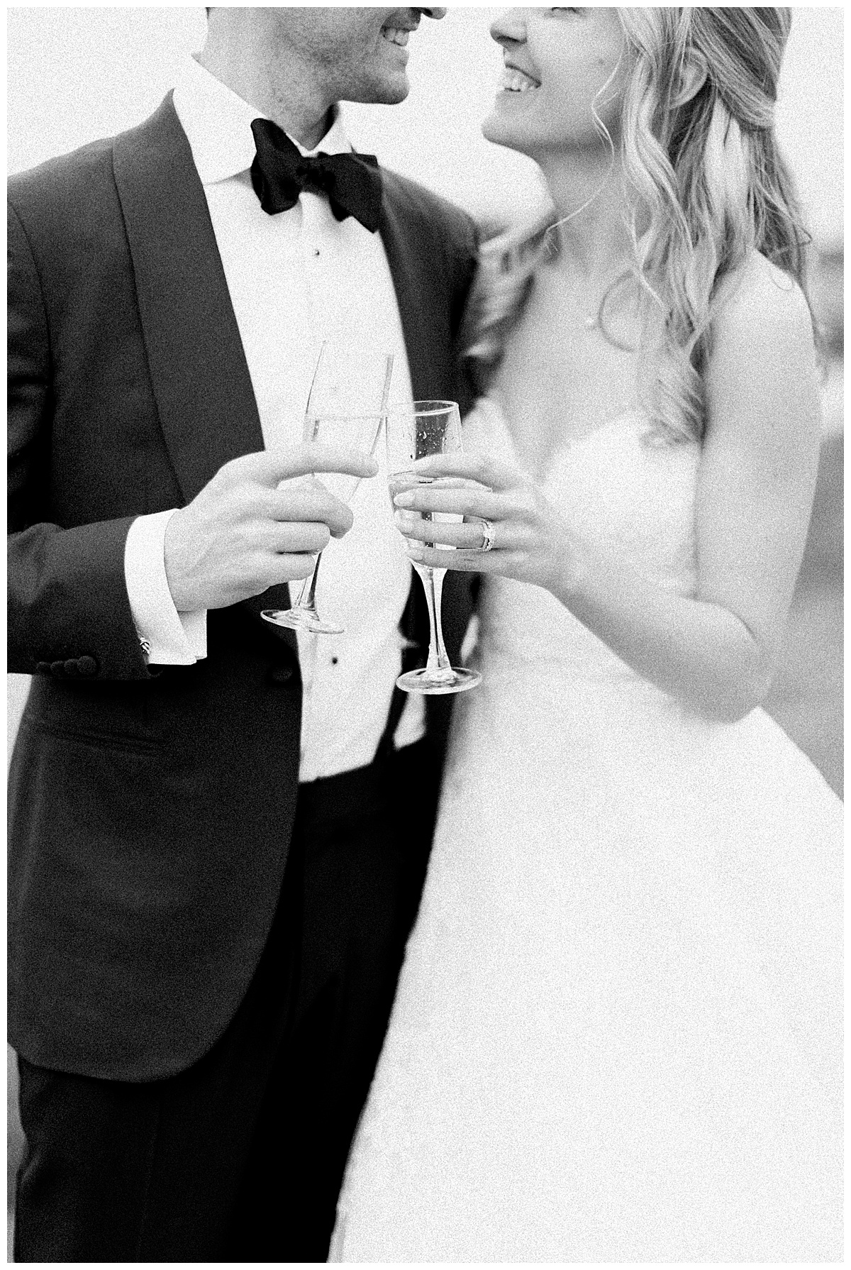 bride and groom with champagne toast in black and white 