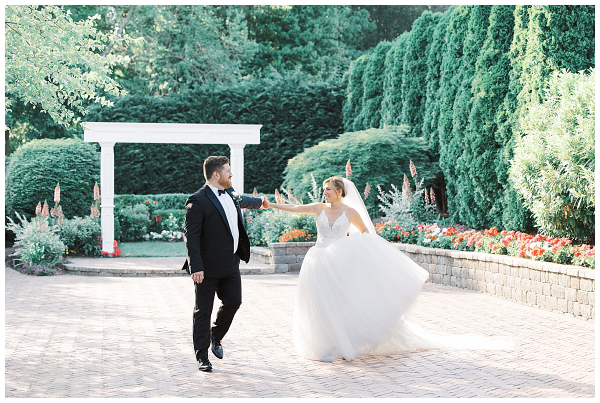 Bride and groom casually walking together in gardens at The Mill Lakeside Manor.. 