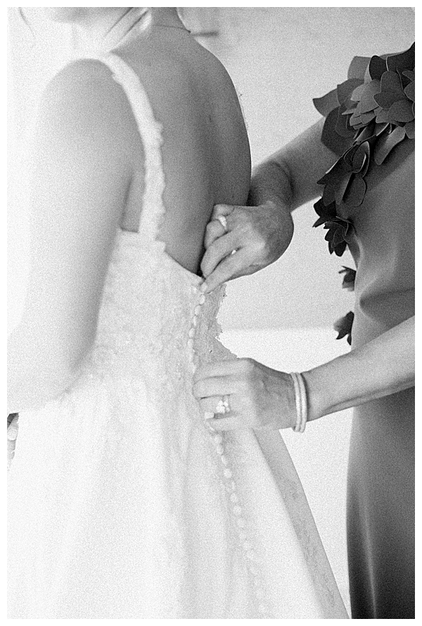 Bride putting on dress at Bonnet Island Estate with elegant details