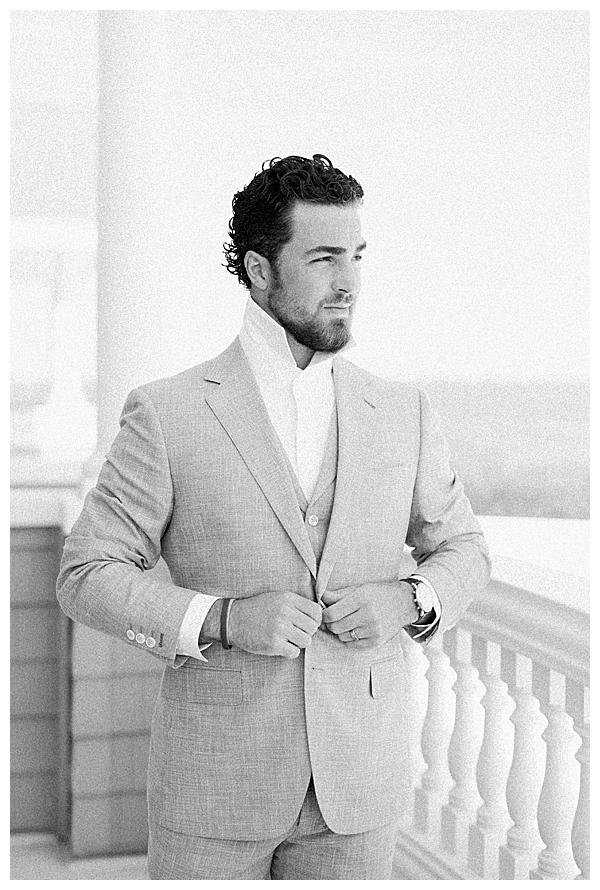 Groom putting on jacket before wedding ceremony in New Jersey