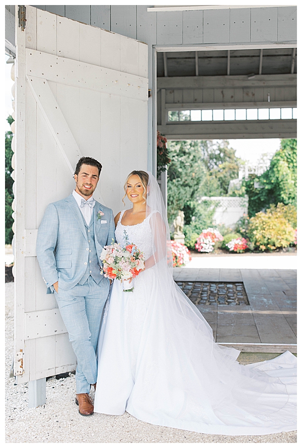 bride and groom by barn doors