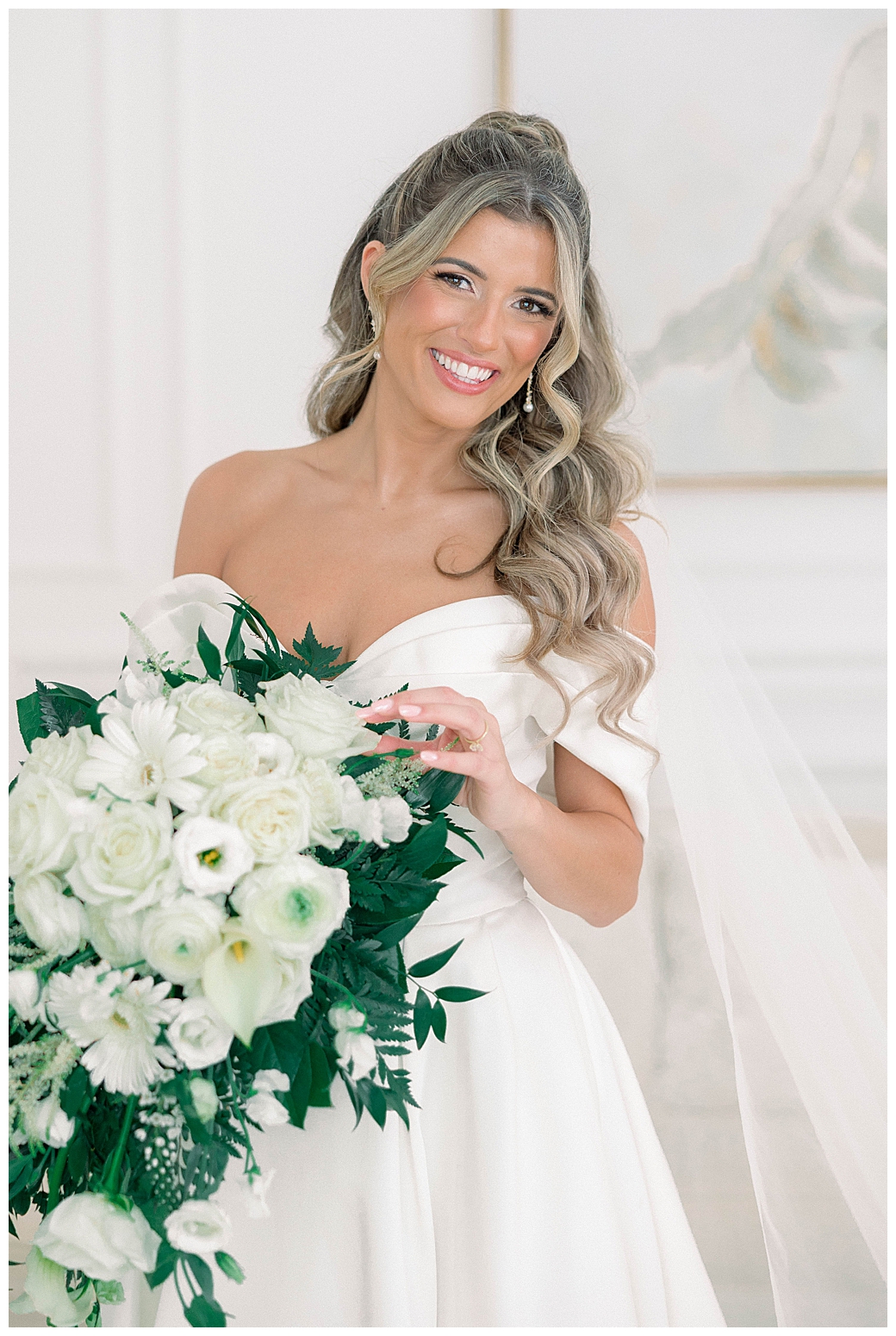 Bridal portrait with soft window light illuminating the bride's veil and gown in the getting-ready suite