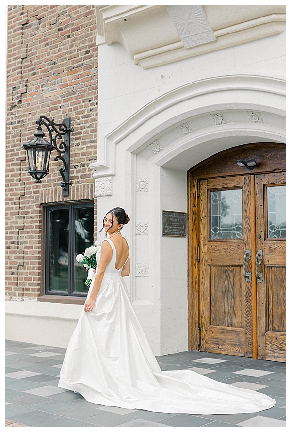 Bride and groom posing in front of The Tilling House building on their wedding day