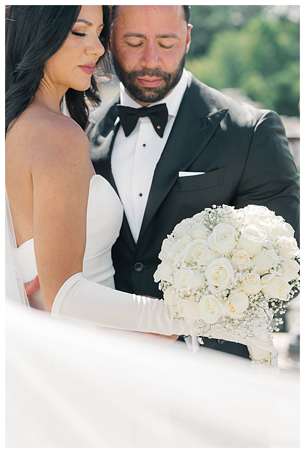 close up bride and groom with white flower bouquet 