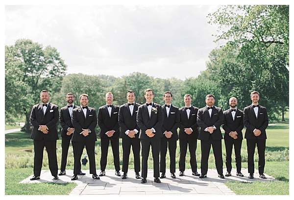 Groomsmen and groom portrait with rolling green background