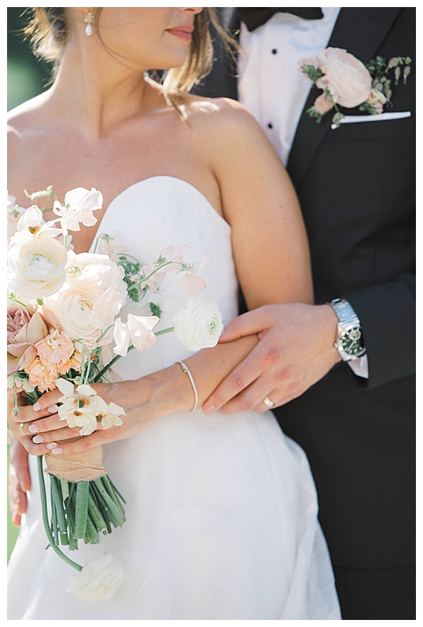 Bride and groom holding bouquet together at Fiddler’s Elbow