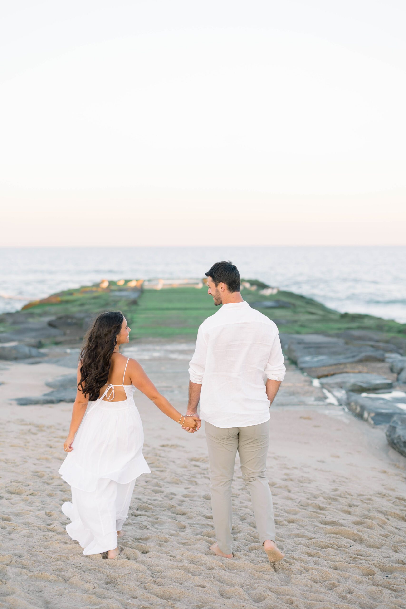 Monmouth County engagement photographer capturing couple walking along the shoreline