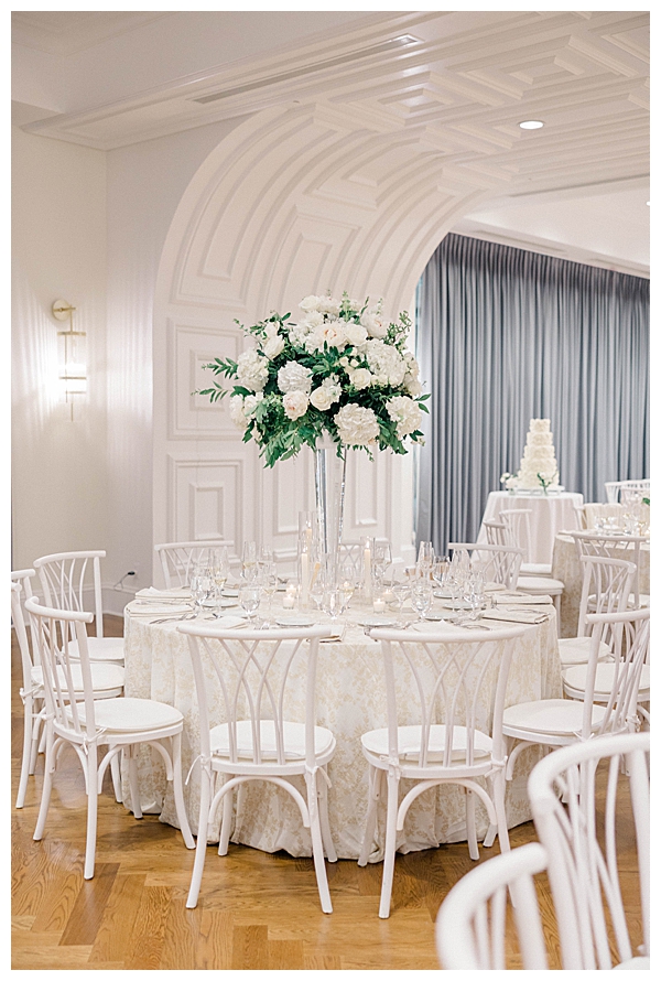 Neutral toned reception decor with white blooms and greenery throughout the space
