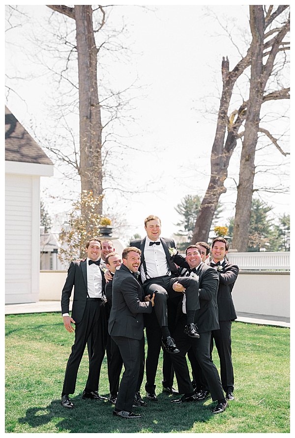 Full bridal party photo at the Ryland Inn with light blue and sage green dresses and white florals