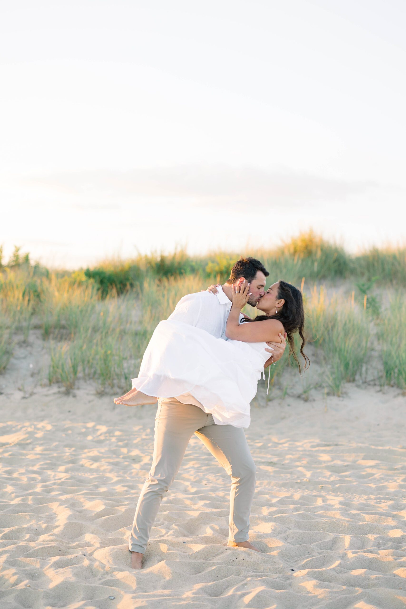 Spring Lake NJ beach engagement session with bride-to-be in a flowing white dress on the sand