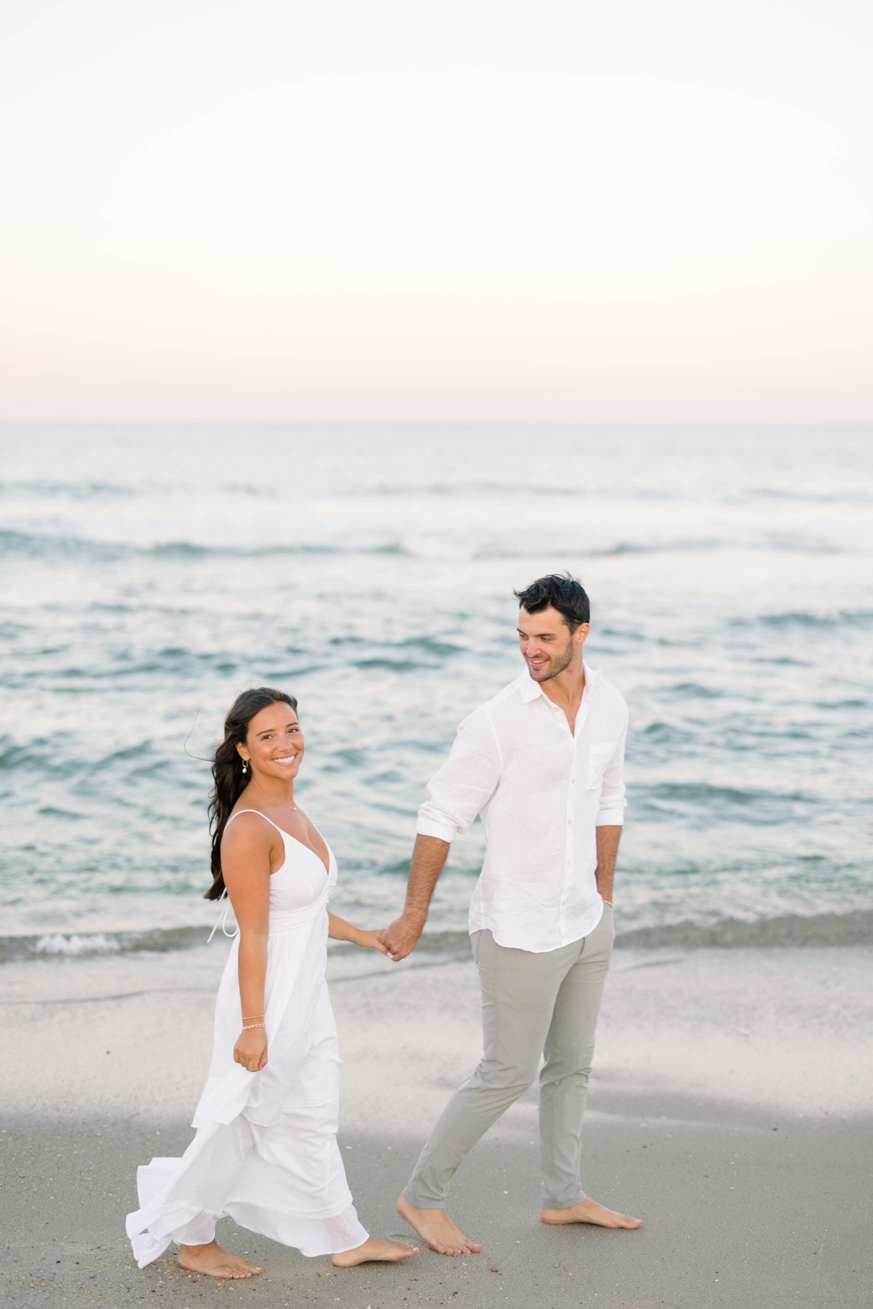 Spring Lake NJ engagement session couple strolling along the shoreline at dusk