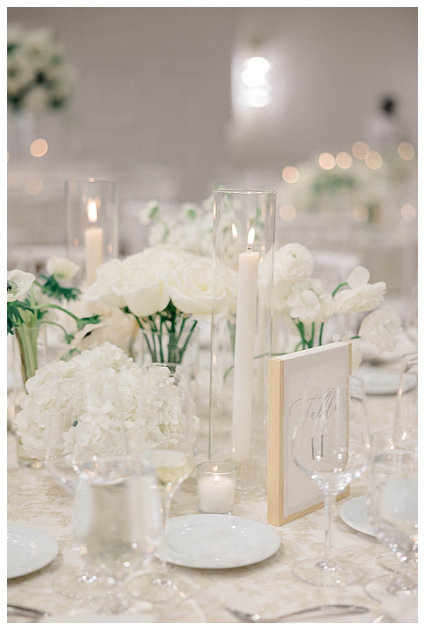 Sweetheart table with lush white and green floral arrangements at the reception