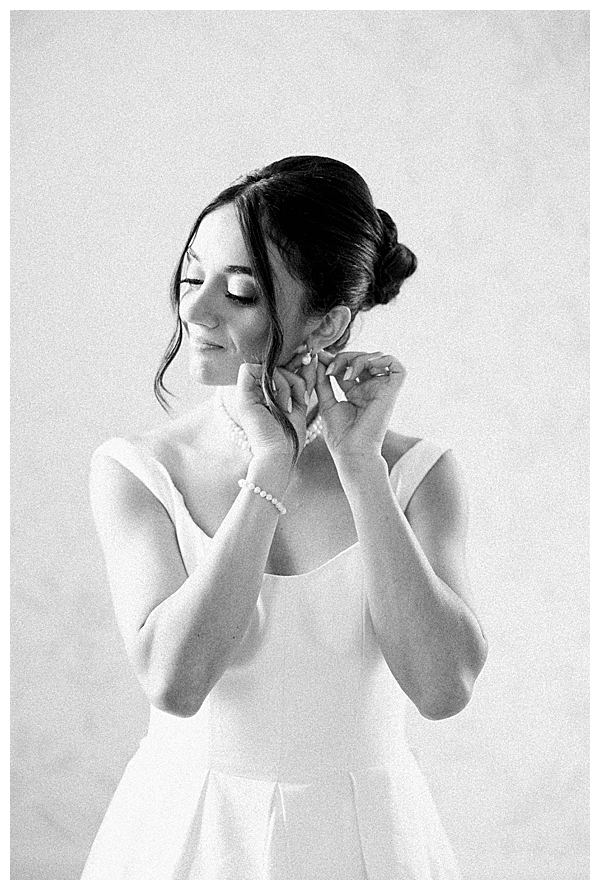 Bride putting on earring