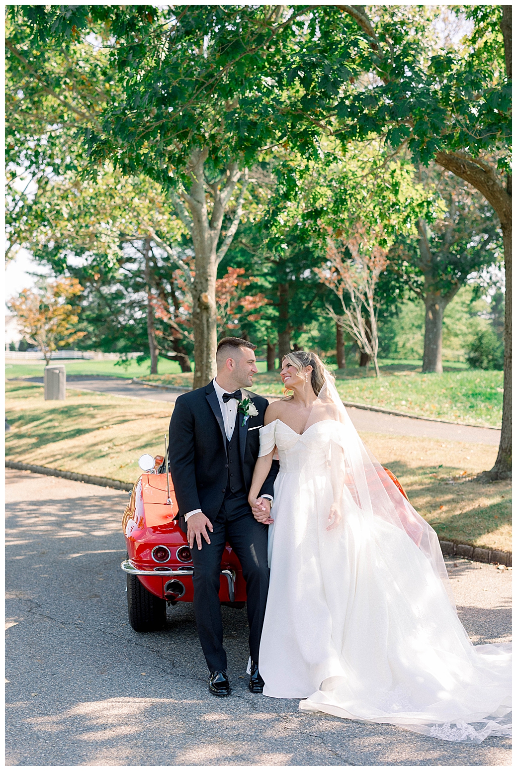 bride and groom with red sports car