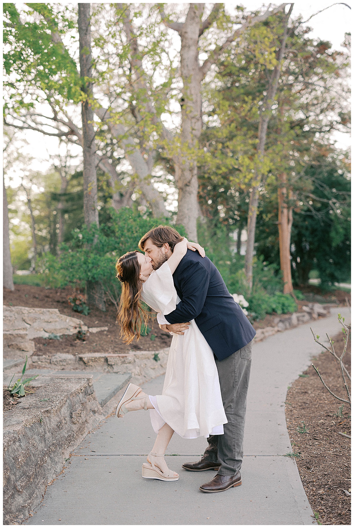 Christie and Kyle walking hand in hand through Divine Park at golden hour in Spring Lake