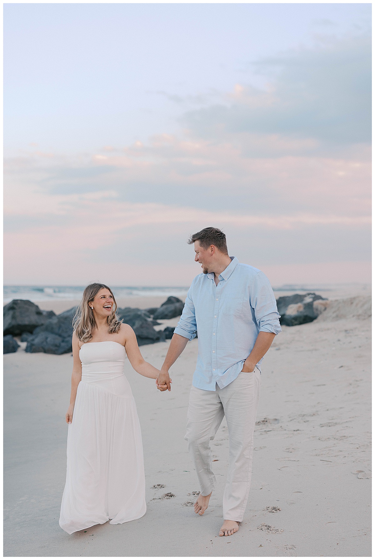 Couple walking barefoot on Sea Girt beach at golden hour, New Jersey engagement photography
