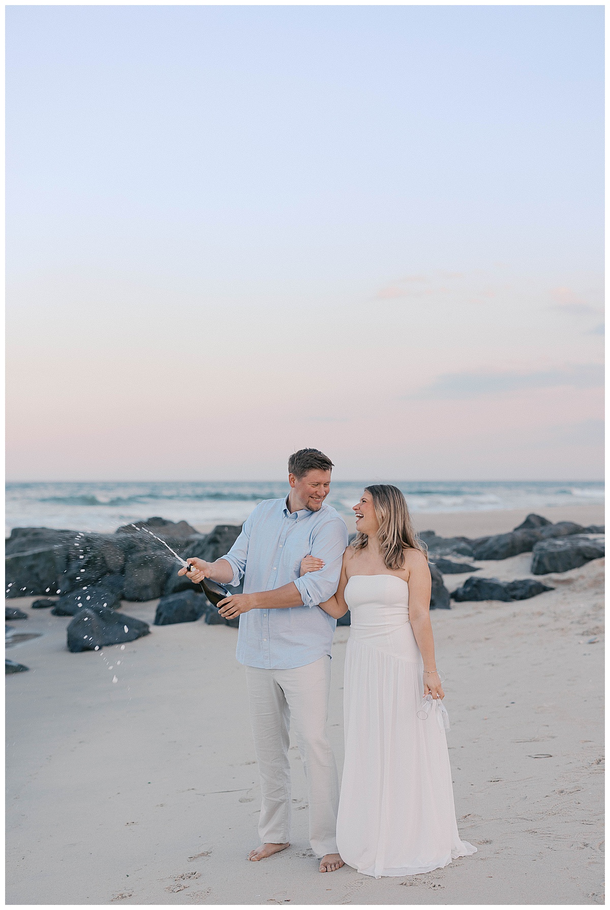 Amanda in a white gown at sunset on Sea Girt beach during her engagement session