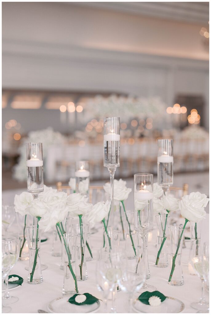 Tablecloth detail with charger plates, calligraphy place cards, and a candle in soft focus